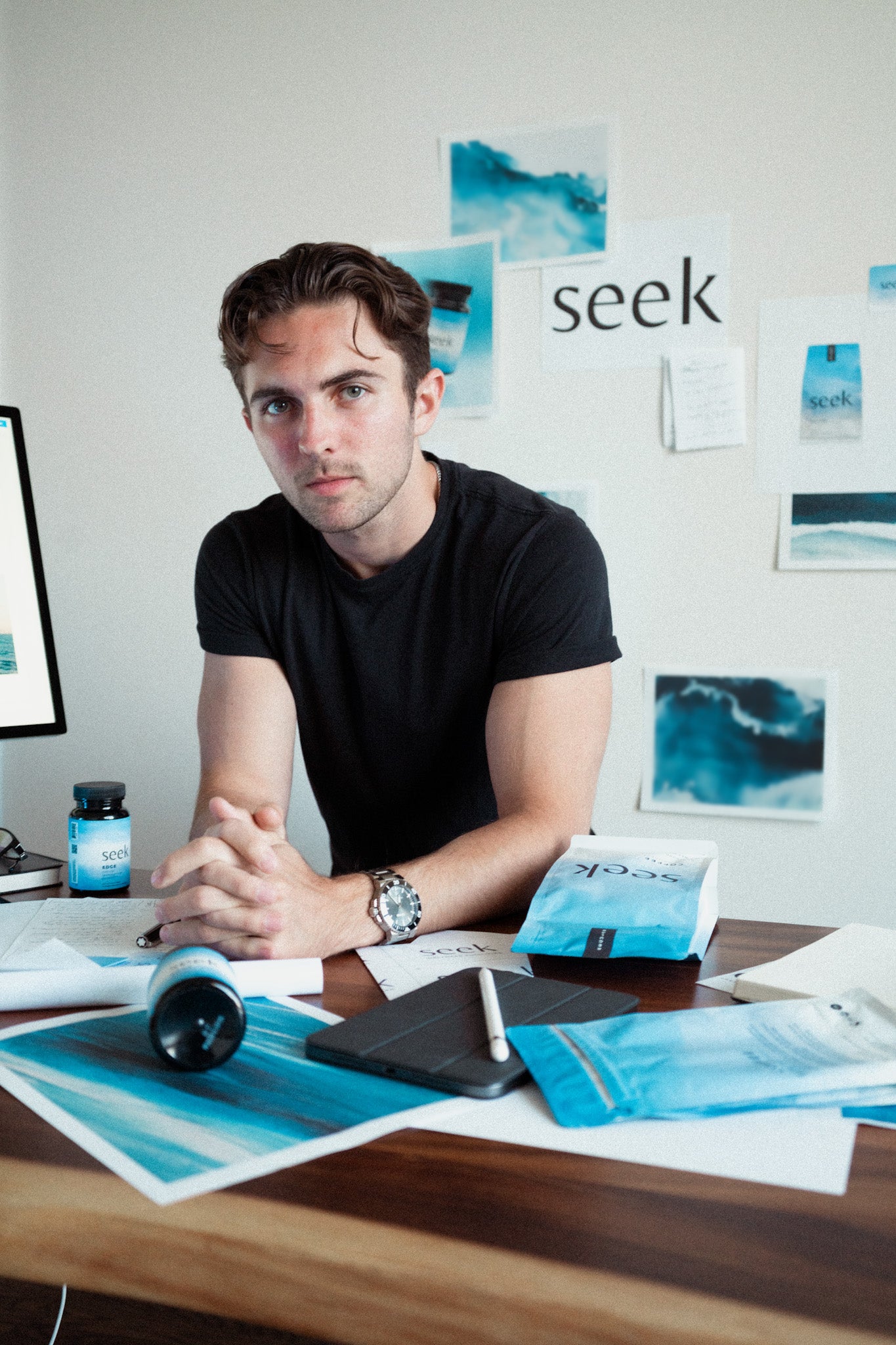 Will, co-founder of Seek® Coffee, at his desk with Seek® products and brand materials. Inspired by his family's health journey and personal experiences with wellness challenges, Will left college to build a purpose-driven coffee brand. His mission with Seek® is to inspire others to pursue health, authenticity, and purpose through the simple ritual of a clean cup of coffee.