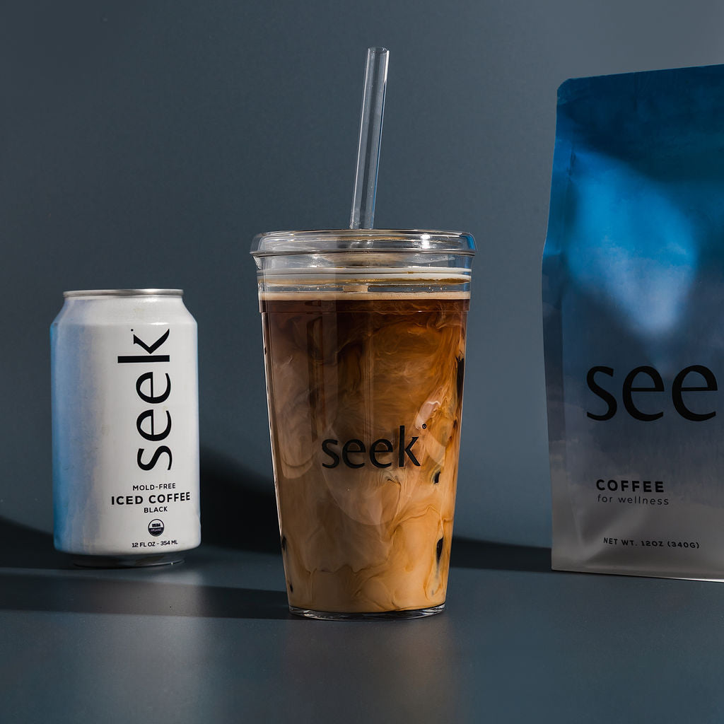 Iced coffee with a can and package of 'seek' brand on a dark background