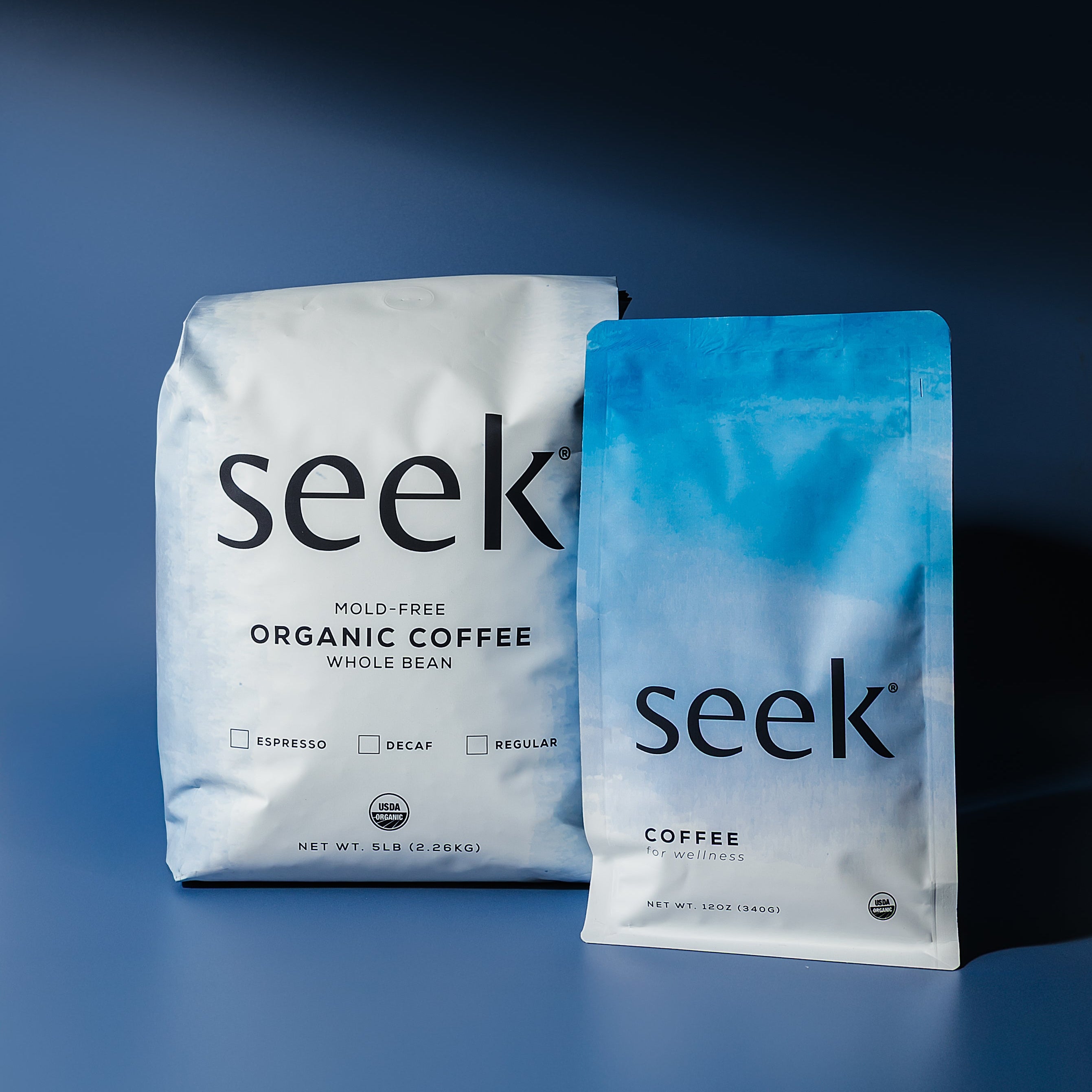 Two 'seek' coffee packages on a blue background
